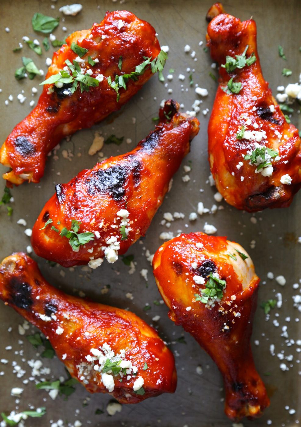 Baked buffalo spicy chicken drumsticks, finished with blue cheese