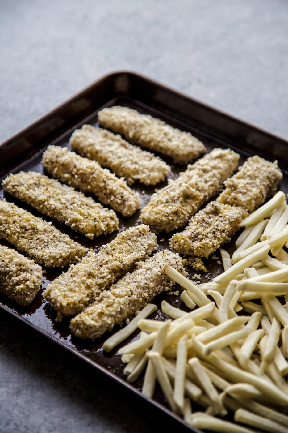 Baked Za'atar Fish Sticks and Chips on a sheet pan ready to baked