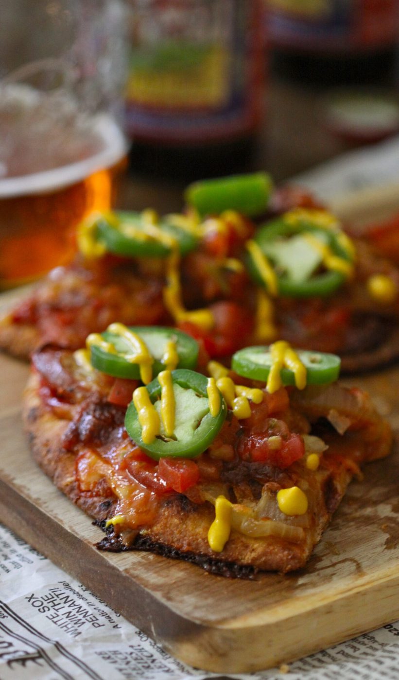 Chicken andouille naan pizza, finished with pico de gallo and jalapenos