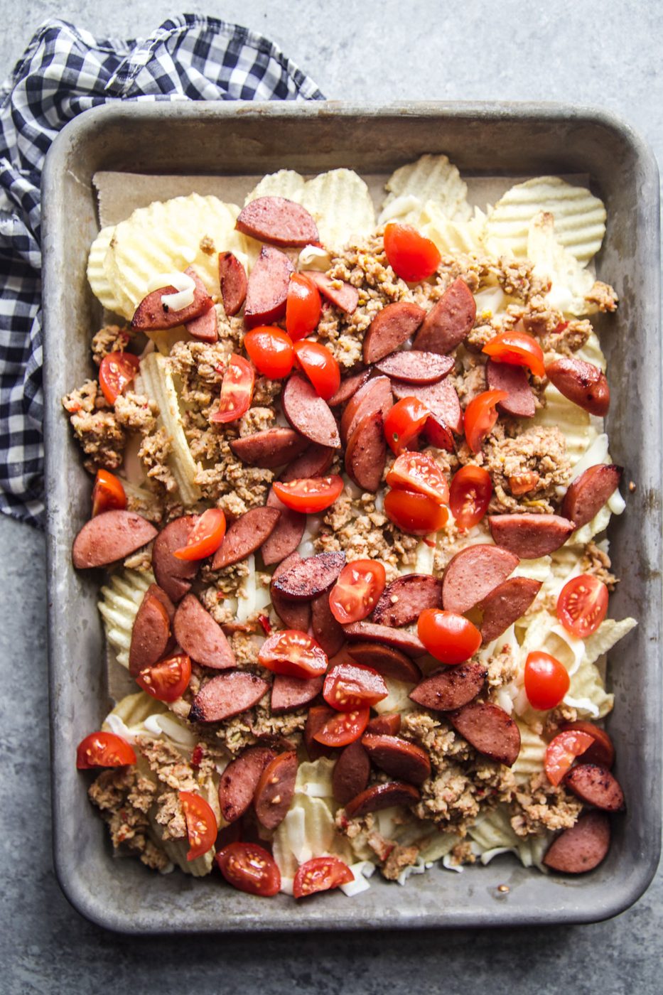 tray with chips, chicken, sausage, and tomatoes