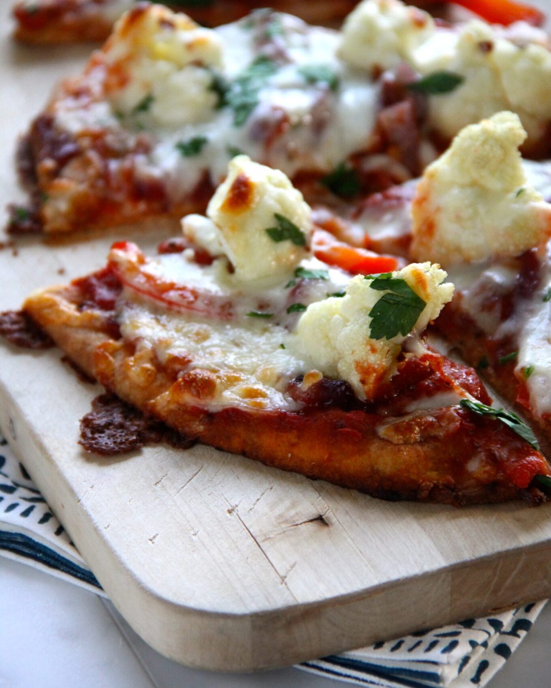 Naan pizza, finished with roasted cauliflower, red pepper, and caramelized onion