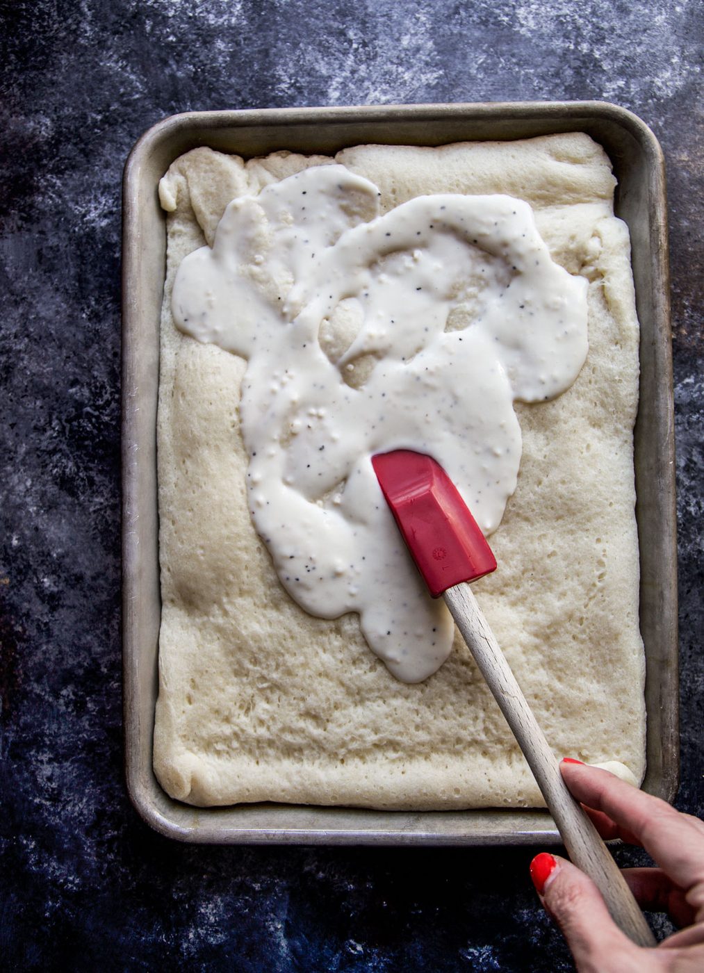 white garlic sauce spreading on pizza dough