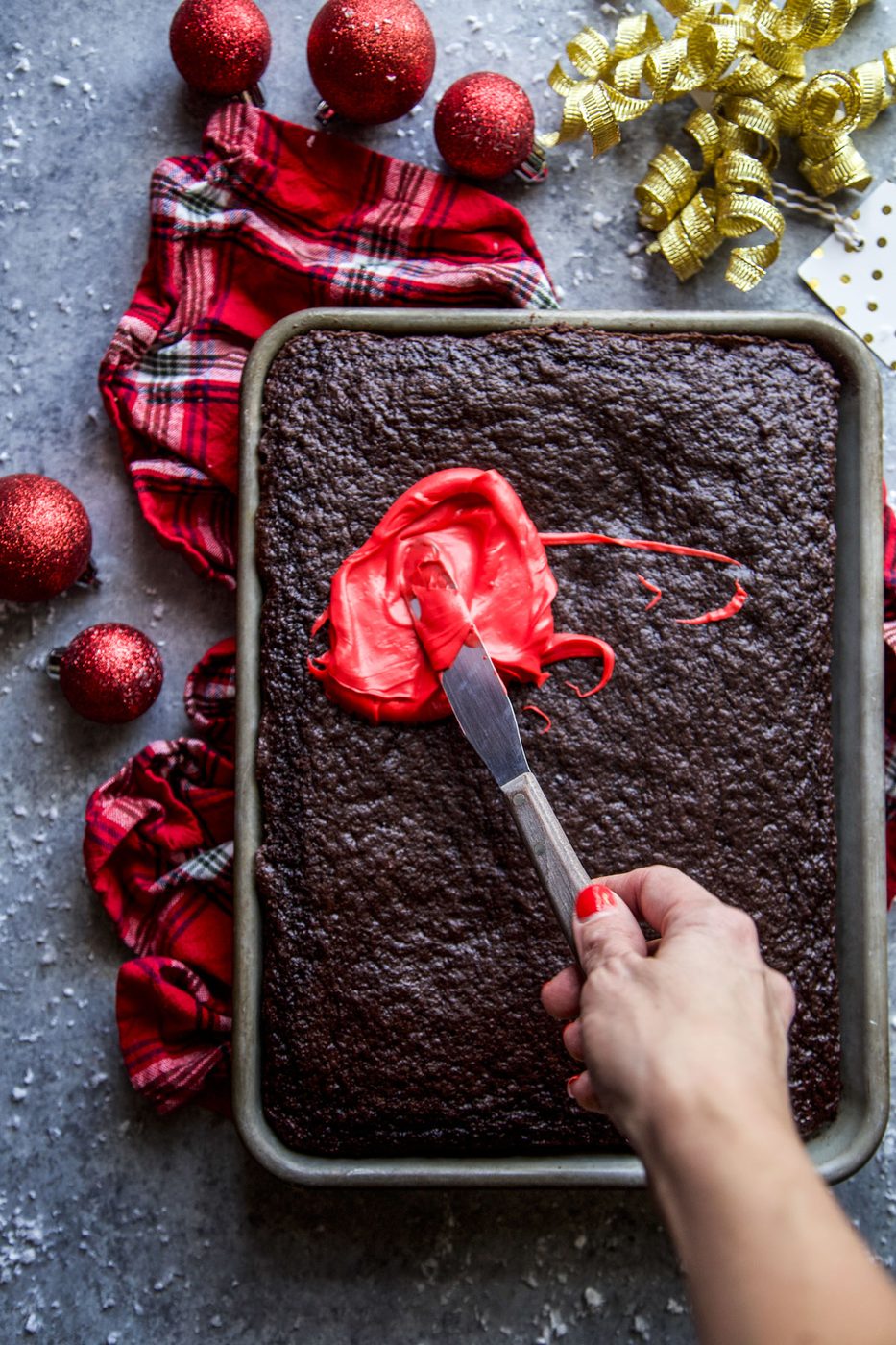 chocolate sheet cake being frosted
