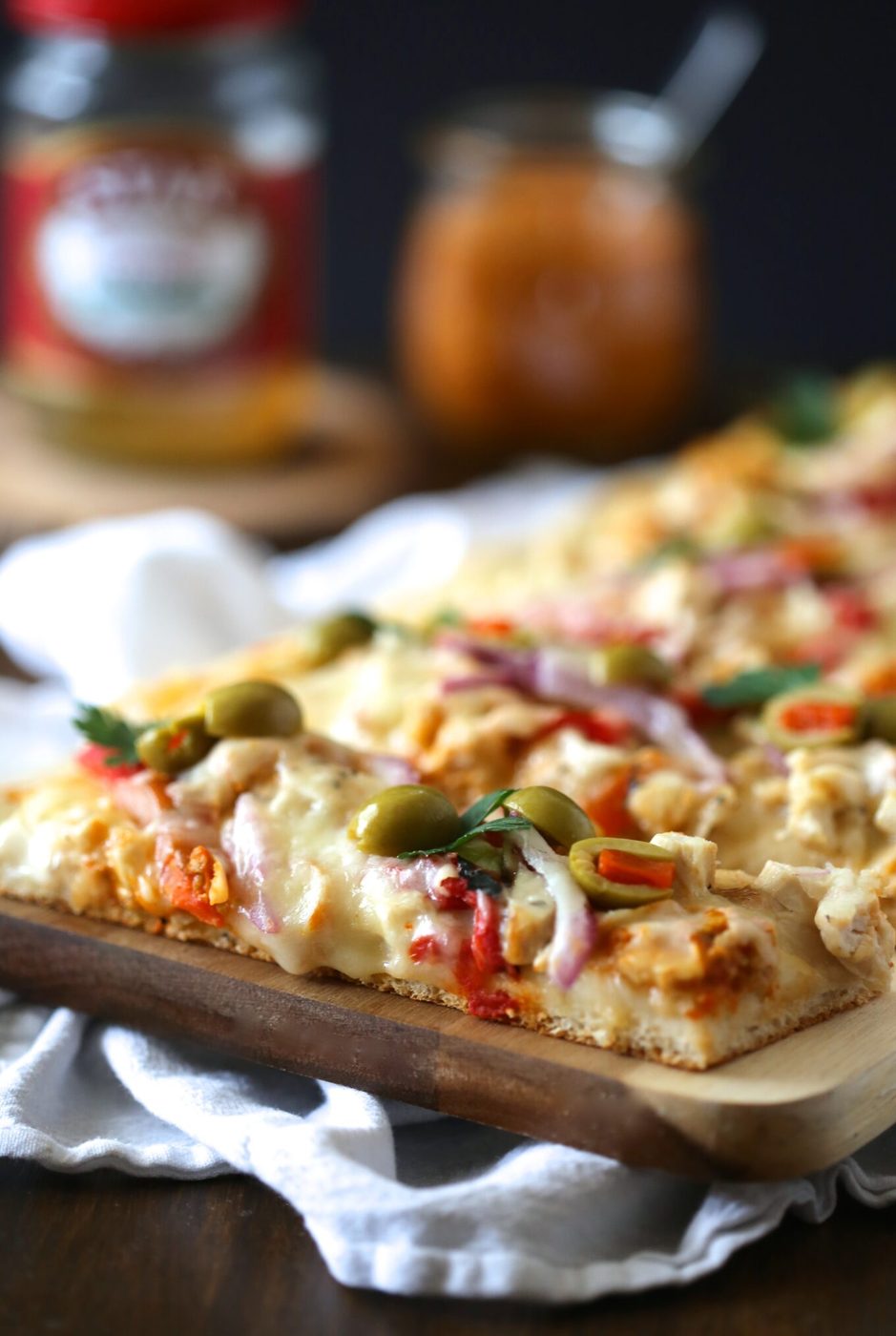 Olives and roasted red peppers on tunisian chicken pizza