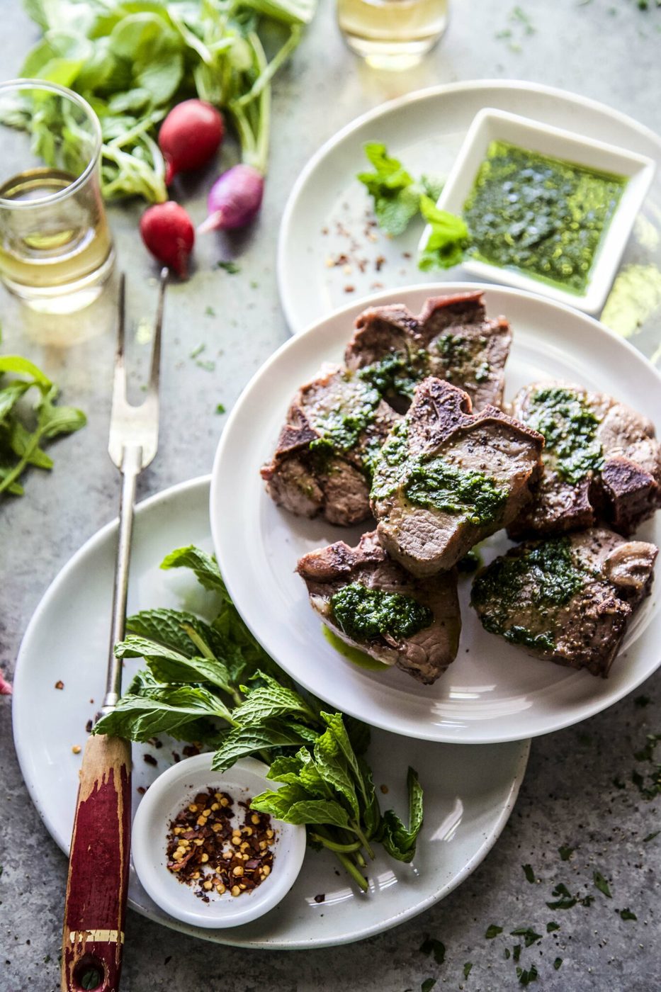 seared lamb loin chop with spinach salsa verde on a table