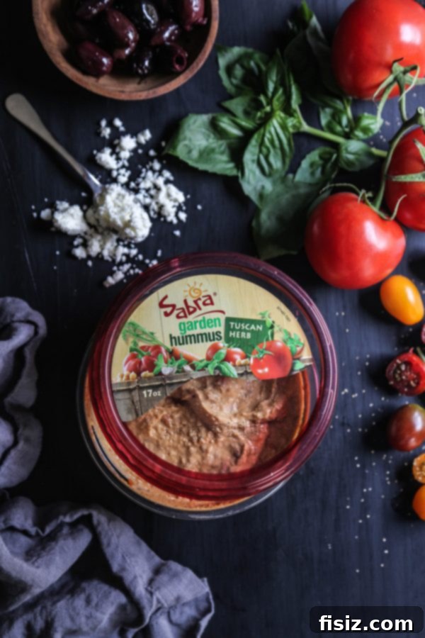 Creamy Four Cheese Greek Pizza Dip with Tuscan Herb Hummus 4 Scooping into Four Cheese Greek Pizza Dip with Tuscan Herb Hummus