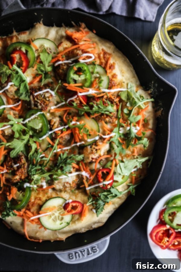 Close-up of Chicken Meatball Banh Mi Skillet Pizza, topped with fresh vegetables.