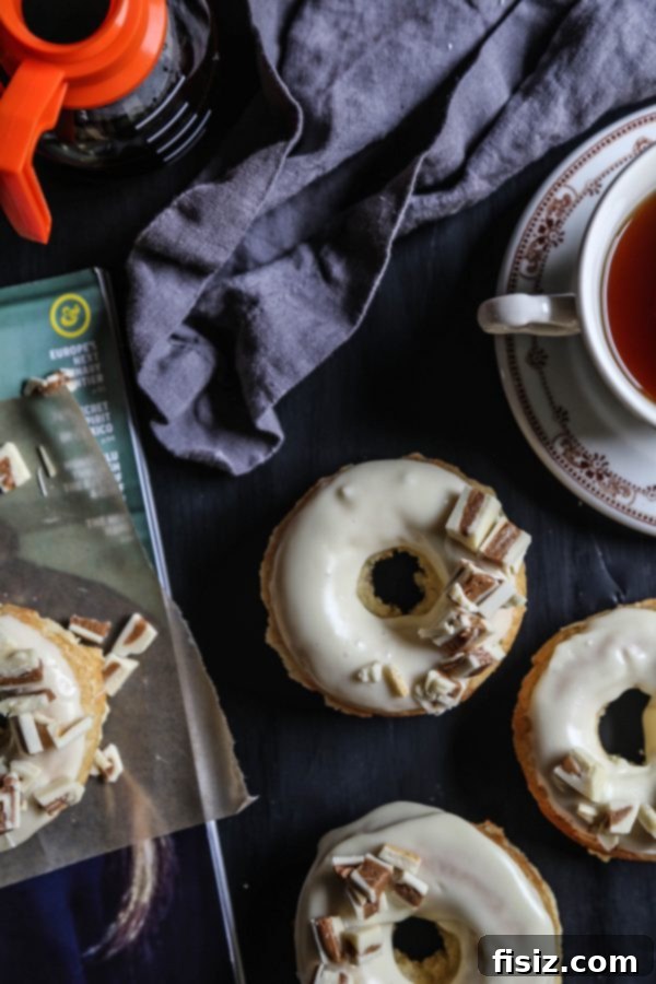 Baked White Chocolate Doughnuts with Peanut Butter Crumble 5 A stack of freshly baked White Chocolate Doughnuts with rich ganache and peanut butter crumbles