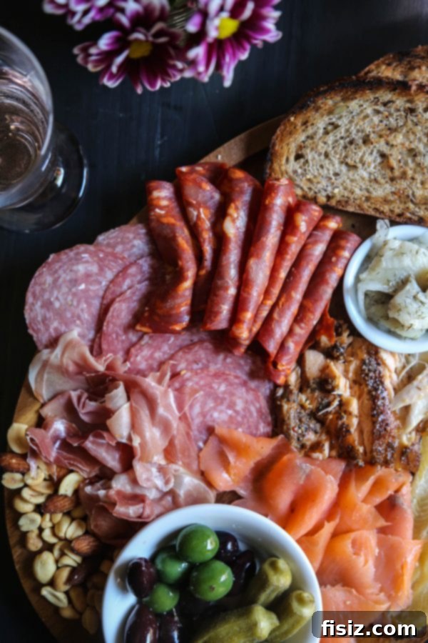 The Definitive Seafood and Charcuterie Board 4 Overhead view of a beautifully arranged Fish and Meat Board with various seafood, charcuterie, and garnishes