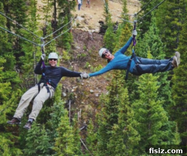 A close-up of a person on a zip line, highlighting the excitement and the safety gear, with blurry mountain scenery in the background.