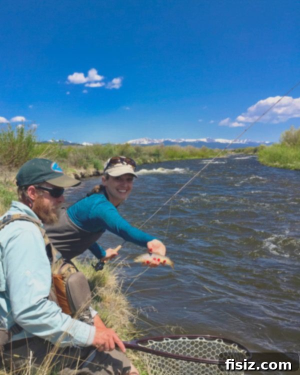 A successful catch: a beautifully vibrant trout held proudly, showcasing the excellent fly fishing opportunities in Leadville, Colorado.