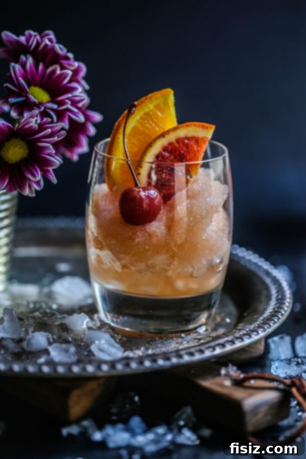 Frozen Old Fashioned 5 Two glasses of Old Fashioned Cocktail Slushie on a rustic table, ready for summer enjoyment