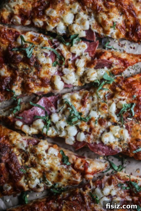 Smoked Mozzarella, Salami and Hominy Pizza 6 Two halves of a delicious homemade pizza, one with pesto and vegetables, the other with marinara and pepperoni