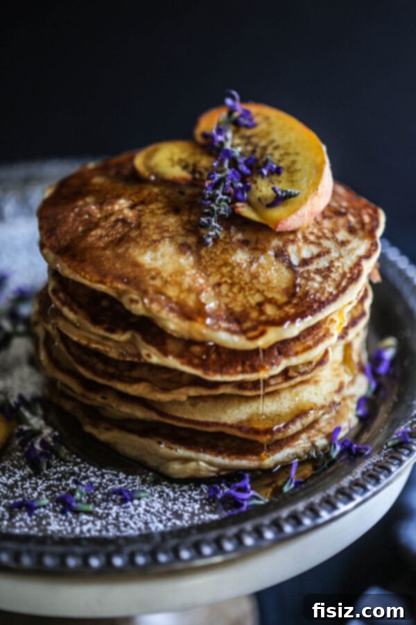 Decadent Peach and Bacon Pancakes with Lavender Butter Syrup 2 Giant stack of fluffy Peach and Bacon Pancakes topped with lavender butter syrup, fresh peaches, and crispy bacon bits, ready for a gourmet breakfast.