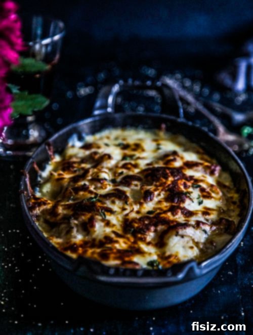 French Onion Gnocchi Gratin 3 Close-up of golden-brown French Onion Gnocchi Casserole with melted cheese and visible caramelized onions, garnished with fresh thyme.