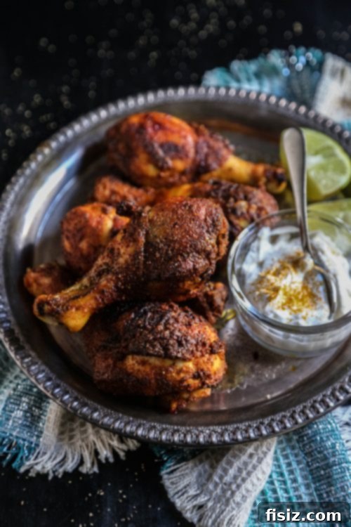 Sticky Turmeric Honey Drumsticks 4 Turmeric and Honey Glazed Drumsticks on a baking sheet with spices