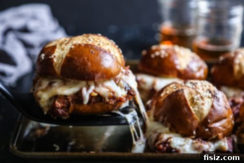 A tray of Oven Baked Pulled Pork Sliders with Beer Cheese Sauce, fresh from the oven