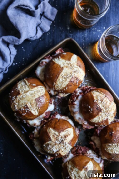 Beautifully arranged Oven Baked Pulled Pork Sliders with Beer Cheese Sauce on a serving platter