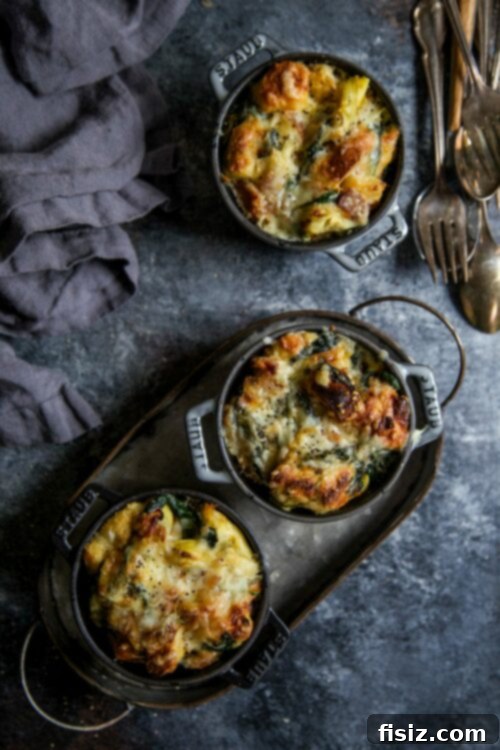 Mini Bacon Spinach and Artichoke Challah Bread Puddings 6 Mini Bacon Spinach Artichoke Challah Bread Puddings in ramekins, close-up with a fork