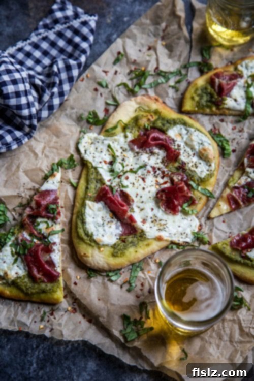 Creamy Avocado Pesto Flatbread with Soppressata and Melted Mozzarella 6 A single slice of Mozzarella and Soppressata Flatbread with Avocado Pesto garnished with fresh basil