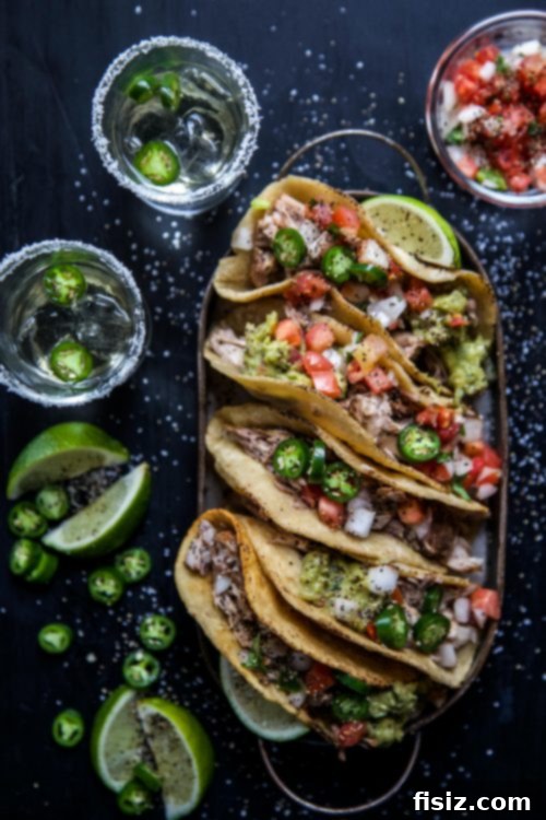Close-up of a perfectly garnished Loaded Carnitas Puffed Taco with fresh cilantro and lime