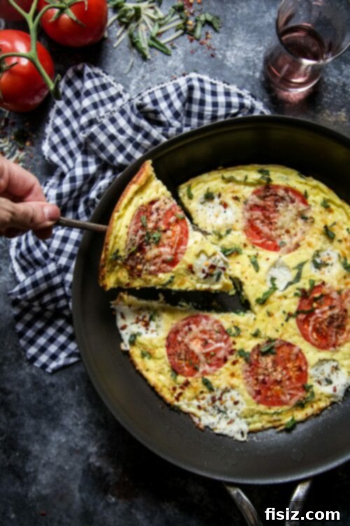 Margherita Frittata Bake 2 Close-up of a delicious Caprese Frittata Pizza, showcasing vibrant roasted tomatoes, melted cheese, and a hint of fresh basil.
