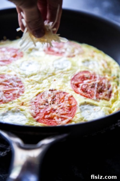 Margherita Frittata Bake 4 A freshly baked Caprese Frittata Pizza resting in a cast iron skillet, ready to be served, highlighting its appealing golden crust and colorful toppings.