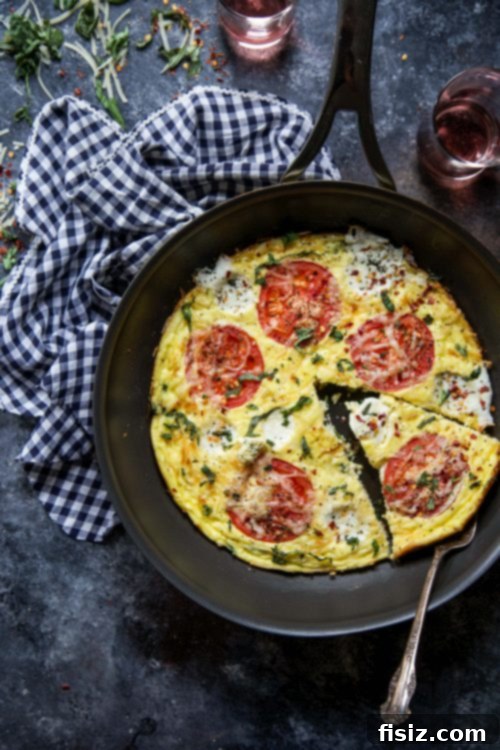 Margherita Frittata Bake 6 A beautifully garnished slice of Caprese Frittata Pizza, showcasing its layers and fresh basil, ready to be enjoyed.