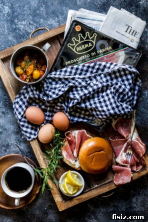 Gourmet Prosciutto Egg Sandwich with Tarragon Tomato 3 Close-up of a Prosciutto and Egg Sandwich on a wooden board