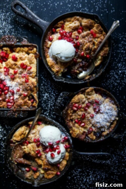 Apple Pomegranate Ginger Cobbler baking in a rustic cast iron skillet