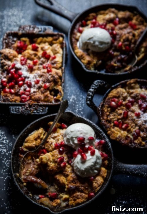 Mini cast-iron skillets filled with Apple Pomegranate Ginger Cobbler, freshly baked and golden