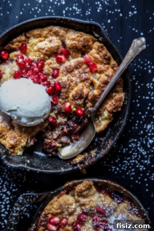 Finished Apple Pomegranate Ginger Cobbler garnished with pomegranate seeds, ice cream, and mint