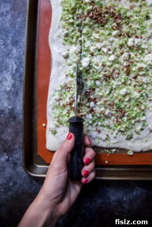 Savory Pull Apart Pizza with Blue Cheese, Pecans and Brussels Sprouts 4 Hand pulling a piece of the Brussels Sprout, Pecan, and Blue Cheese Pull Apart Pizza