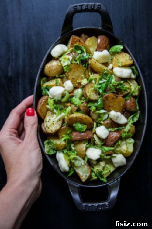 Golden Spud & Sprout Poutine 3 Close-up of Roasted Baby Potato Brussels Sprout Poutine, showing golden potatoes, green sprouts, and melted cheese curds.