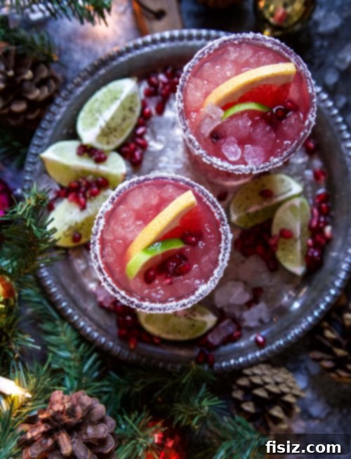 Crimson Ginger Paloma 4 Three beautiful glasses of Ginger Pomegranate Paloma, garnished with lime and pomegranate seeds