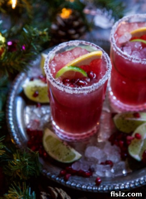 Crimson Ginger Paloma 5 Overhead view of a Ginger Pomegranate Paloma with ingredients and garnishes