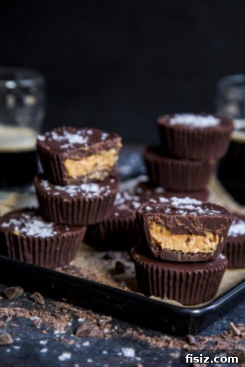Dark Chocolate Stout Peanut Butter Cups 4 Ingredients for Dark Chocolate Peanut Butter Guinness Cups laid out on a wooden surface, including chocolate chips, peanut butter, and a bottle of Guinness