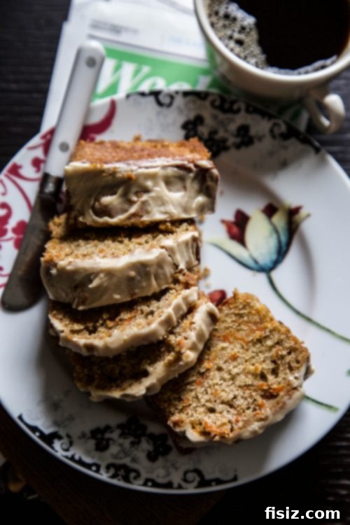 Spiced Carrot Loaf with Tahini Coconut Frosting 4 A whole Carrot Cake Bread loaf with Tahini Coconut Buttercream, sitting on a rustic wooden board, ready for slicing.