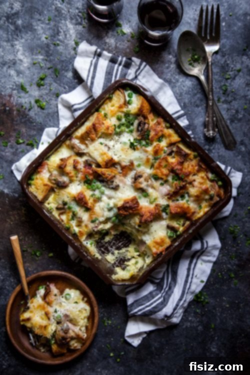 A slice of Bacon, Burrata & Smoked Mozzarella Strata served on a white plate, garnished with fresh parsley, showing its layers and melted cheese.