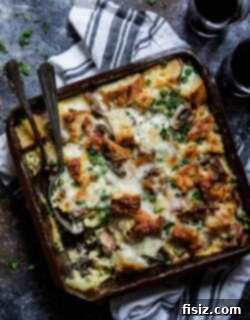 A perfectly baked slice of Bacon, Burrata & Smoked Mozzarella Strata with crispy top, ready to eat.