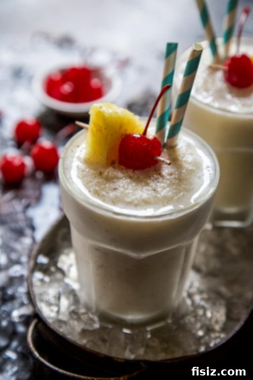 Cardamom Rum Pina Colada Garnished with Pineapple and Cherry