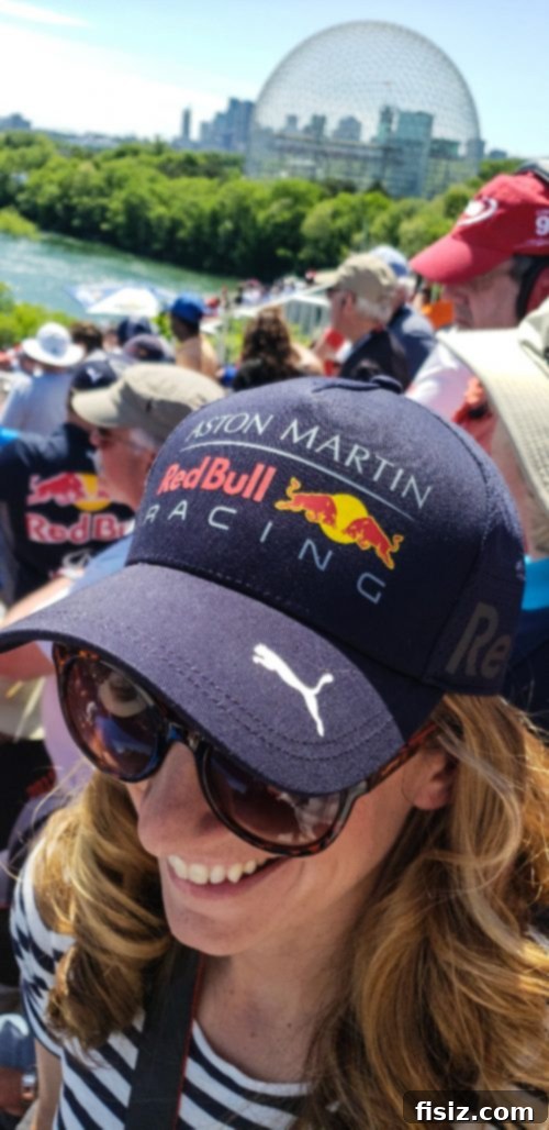Enthusiastic F1 fans in a crowded grandstand, cheering and watching the race.