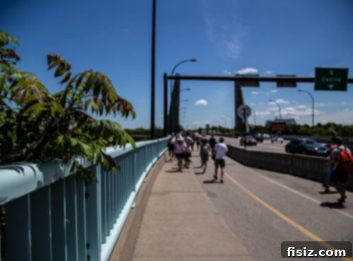 Large crowd of F1 spectators walking on a pathway towards the Circuit Gilles Villeneuve.