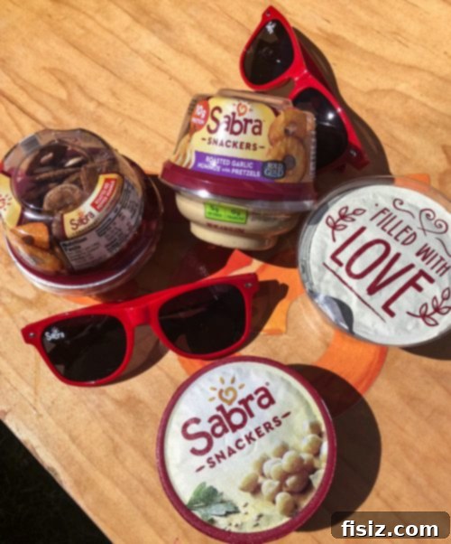Three friends posing playfully with Sabra products at the Kula Market.
