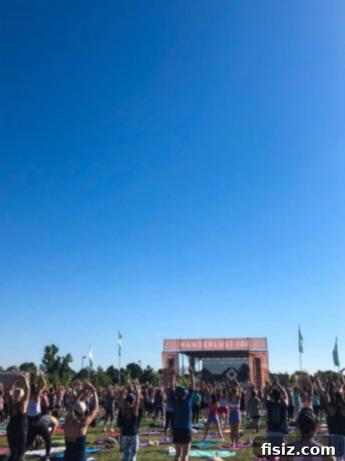 A large group of people gathered under a Wanderlust sign, preparing for a 5K event.