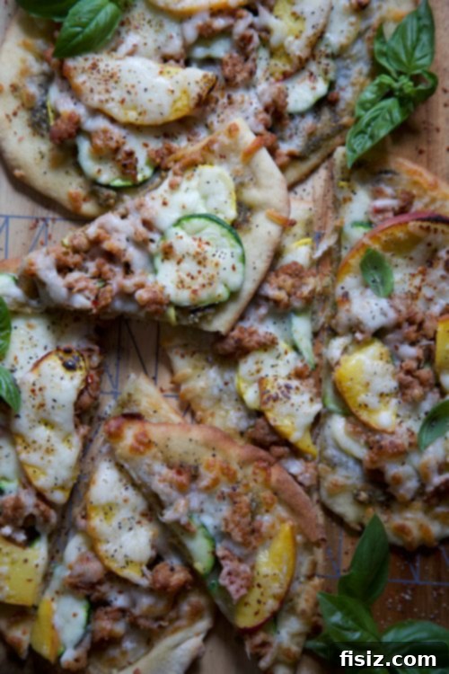 Sweet and Savory Chicken Pesto Flatbread with Summer Peaches and Squash 6 Two baked chicken pesto flatbreads on a wooden cutting board, garnished with fresh basil.