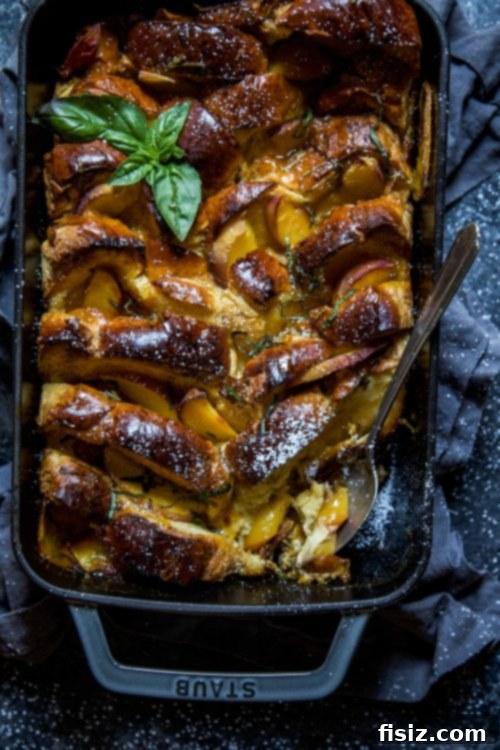 Baked Peach and Basil French Toast 5 A perfectly portioned slice of Peach and Basil French Toast Bake on a white plate, garnished with basil and powdered sugar