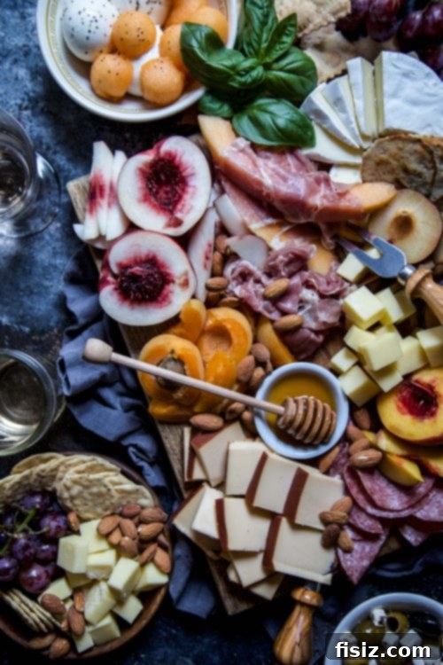 Close-up of a charcuterie board with a focus on fresh stone fruits like peaches and plums.