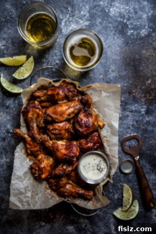 Tender Slow Cooker Chipotle Bourbon Chicken Wings 2 Two hands holding a platter of Slow Cooker Chipotle Bourbon Chicken Wings ready for a tailgate party.