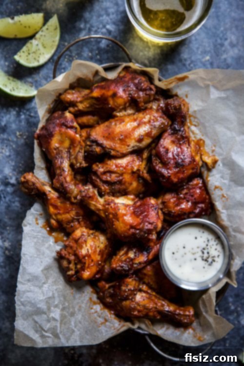 Tender Slow Cooker Chipotle Bourbon Chicken Wings 3 A vibrant tailgate spread featuring Slow Cooker Chipotle Bourbon Chicken Wings and other classic dishes, set up outdoors.